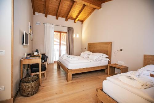 a bedroom with two beds and a desk in it at Agriturismo La Pertica in Costermano sul Garda