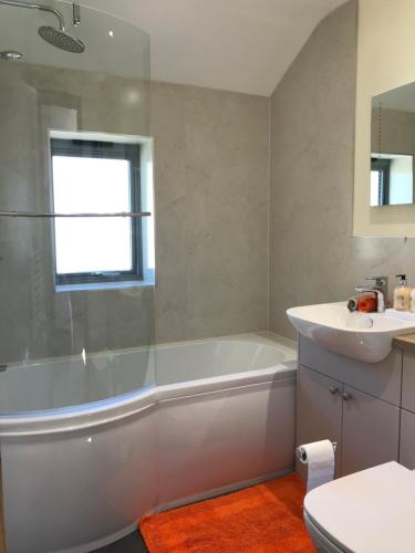 a white bathroom with a tub and a sink at Moelfre B&B in Machynlleth