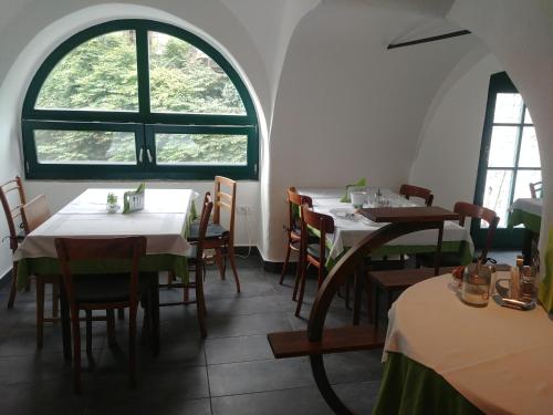 a dining room with tables and chairs and a window at Hotel garni Paleta in Škofja Loka