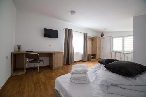 a bedroom with a bed and a desk in it at Casa Burduhos in Câmpulung Moldovenesc