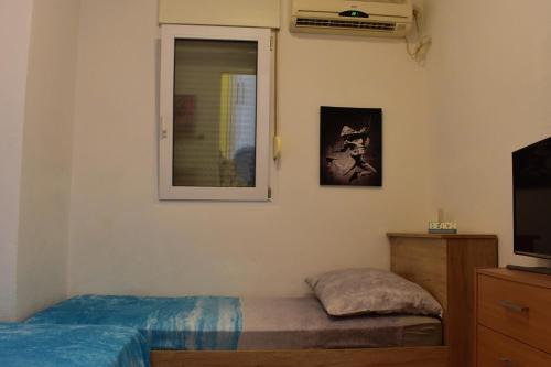 a bedroom with a bed and a window and a television at Apartment Hajdi in Podstrana