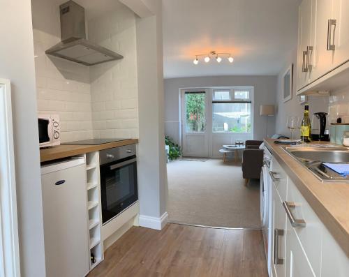 a kitchen with white cabinets and a counter top at Harbour Lights in Penzance