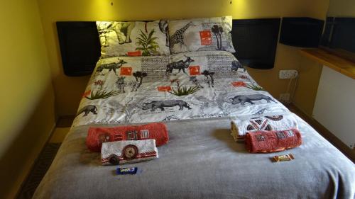 Una cama con colcha de animales. en In Between Home en Lydenburg