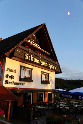 a building with tables and chairs in front of it at Hotel-Berggasthof Schwarzwaldperle in Sasbachwalden