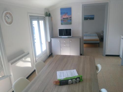 una habitación con una mesa con un libro. en Appartement 62 m2 1er etage avec jardin au rdc, en Saint-Génis