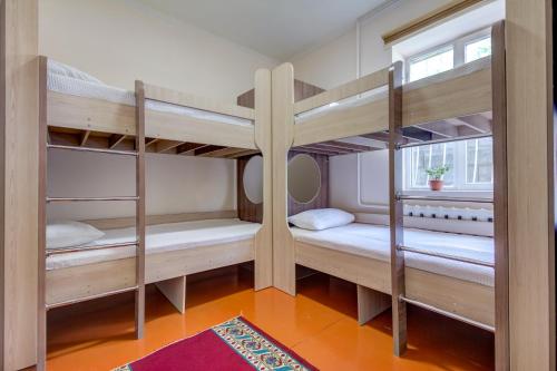 Ce dortoir comprend 2 lits superposés et une fenêtre. dans l'établissement Ayar Hostel Bishkek, à Bishkek