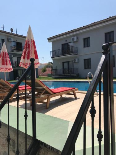 une piscine avec deux chaises longues et un bâtiment dans l'établissement Karyada Hotel, à Çeşme