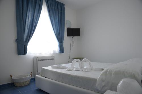 een slaapkamer met een bed met blauwe gordijnen en een raam bij Il Sestante B&B in Condofuri