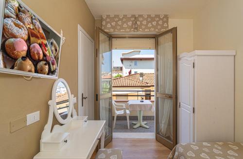 1 dormitorio con vistas a un balcón con mesa en Hotel Mariani, en Lido di Camaiore