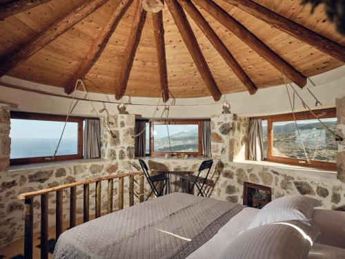 ein Schlafzimmer mit einem Bett in einem Zimmer mit Fenstern in der Unterkunft Anemomilos in Koríthion