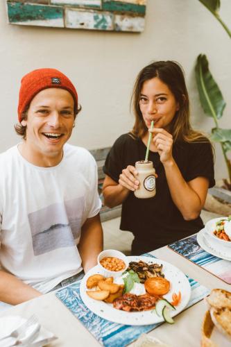 a man and woman sitting at a table with a plate of food at Aloe Again in Jeffreys Bay