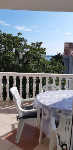 een witte tafel en stoelen op een balkon bij Apartmants Katica in Novalja