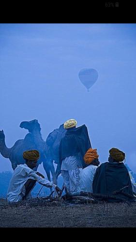 a group of people sitting under a tent with a balloon at Inn Seventh Heaven in Pushkar