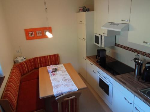una pequeña cocina con sofá rojo y mesa en Haus Niederegger, en Finkenberg