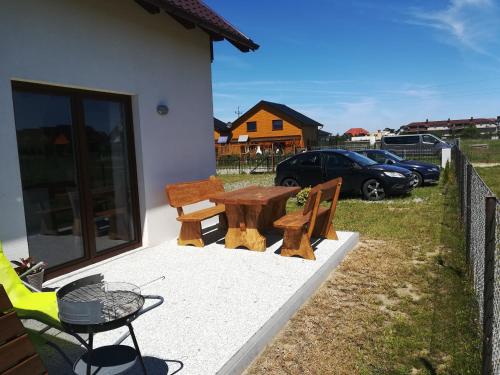 a patio with a table and two chairs and a car at Domki Pod Gwiazdami in Władysławowo