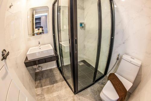 a bathroom with a shower and a toilet and a sink at The Seens Hotel in Krabi town