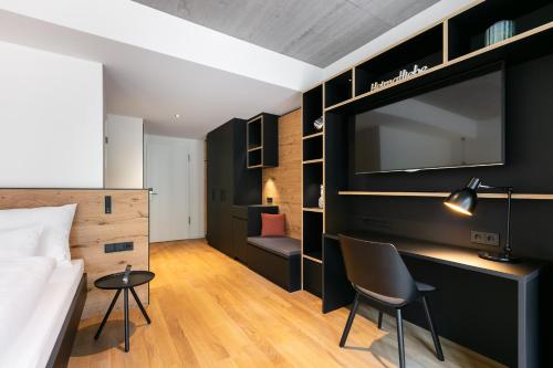 a hotel room with a bed and a large screen tv at Fritz Lauterbad in Freudenstadt