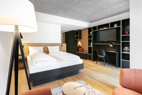 a bedroom with a bed and a desk and a television at Fritz Lauterbad in Freudenstadt