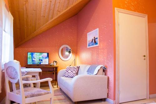 a living room with a couch and a chair at Herranniemi Guesthouse in Vuonislahti