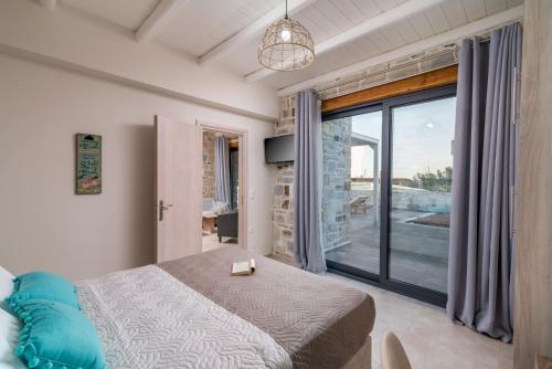een slaapkamer met een bed en een groot raam bij EL.MA.RA. Luxury Villas in Kókkinos Pírgos