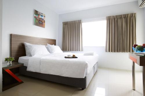 a hotel room with a large bed and a window at Praso Residence in Bangkok