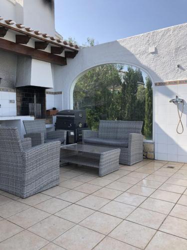an outdoor patio with couches and a grill at Villa Luz del Monte in Denia