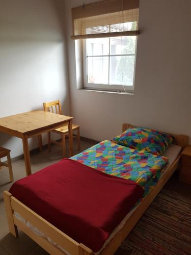 um quarto com uma cama, uma mesa e uma janela em Gościniec Tymawa em Tymawa