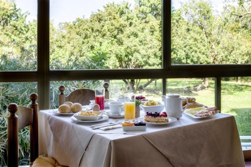 uma mesa com comida para o pequeno almoço em frente a uma janela em Hotel Onda Marina em San Teodoro