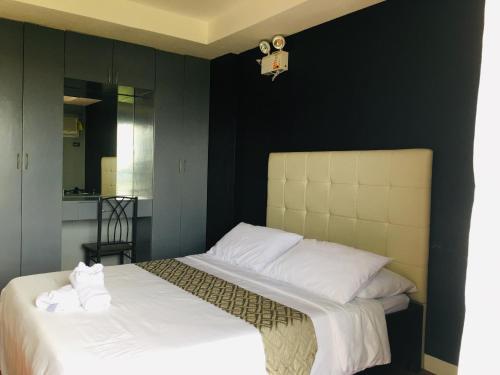 a bedroom with a bed with white sheets and pillows at Rangya Hotel in Tagaytay