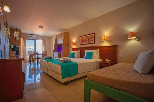 a hotel room with two beds and a balcony at Elounda Residence Resort & Waterpark in Elounda