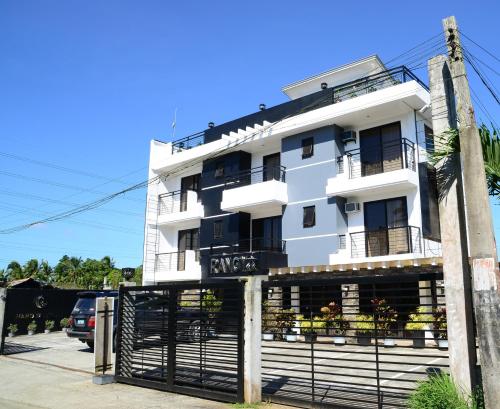 a white building with a fence in front of it at Rangya Hotel in Tagaytay
