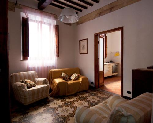 a living room with two chairs and a mirror at Il Balconcino sulle Terme in San Giuliano Terme