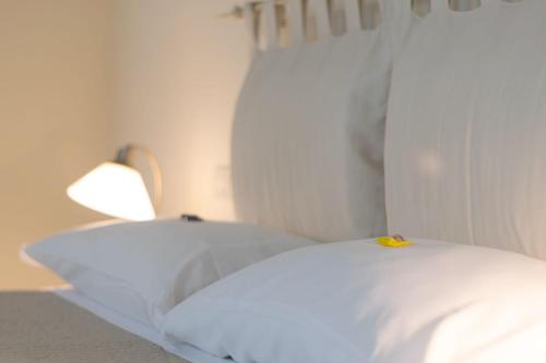 a white bed with a white curtain and a pillow at Juliet House in Verona