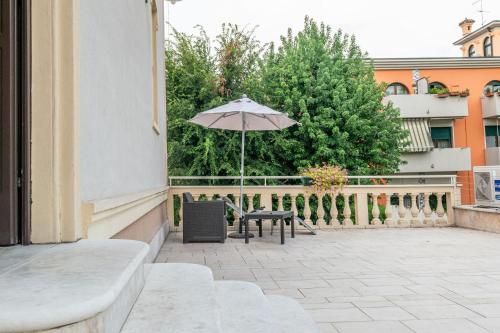 a patio with a table and an umbrella at Juliet House in Verona