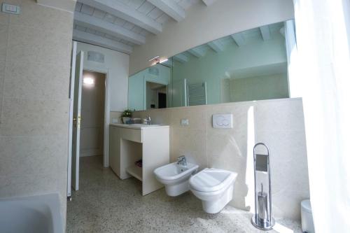 a bathroom with a toilet and a sink and a mirror at Juliet House in Verona