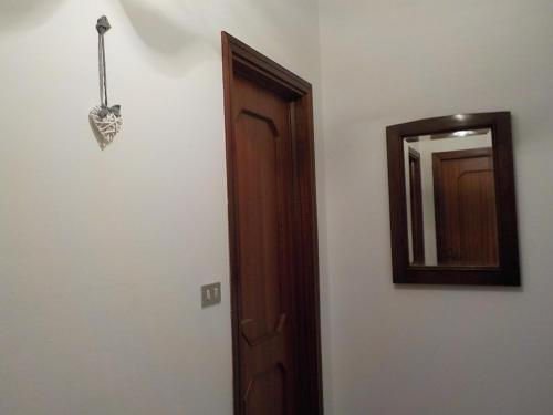 a bathroom with a mirror and a wooden door at Casa Romme in Tornolo