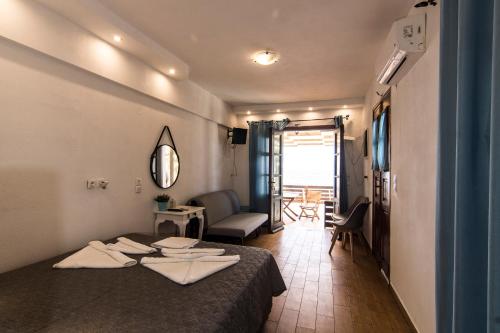 Habitación de hotel con cama y sala de estar. en Nisyros White Wave, en Mandrákion