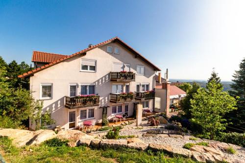 uma casa grande no topo de uma colina em Hotel Zur Aussicht em Hohnstein