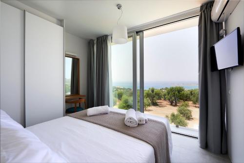 a bedroom with a bed and a large window at Kalypso Residence in Methoni