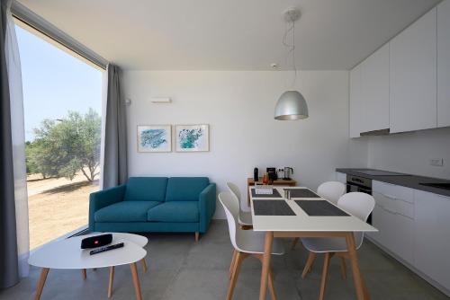 a kitchen and living room with a blue couch and a table at Kalypso Residence in Methoni