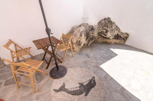 a room with two chairs and a rug and a lamp at Nisyros Views in Mandrakion