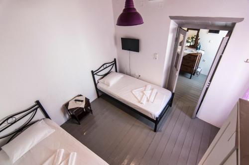 a small bedroom with two beds and a mirror at Nisyros Views in Mandrakion