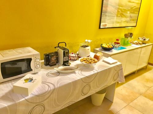 a table with a microwave and some food on it at B&B IL VIALETTO in Orio al Serio