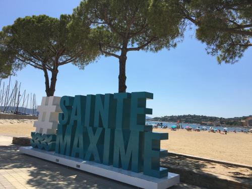 a sign on the beach with trees in the background at Bastide du Levant - 50m plage - Rez de jardin in Sainte-Maxime