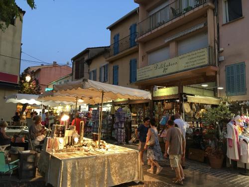 a group of people walking through an outdoor market at Bastide du Levant - 50m plage - Rez de jardin in Sainte-Maxime