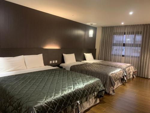 a hotel room with two beds and a window at Fine Hotel in Kaohsiung