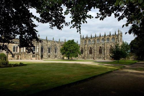 a large stone building with a green lawn in front of it at Cosy two bedroom apartment in Bishop Auckland