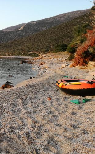 an orange boat sitting on a rocky beach at Lazy Farm in Prásinon