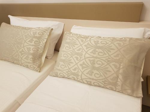 a bed with white sheets and pillows on it at Il Sogno Torino Guesthouse in Turin