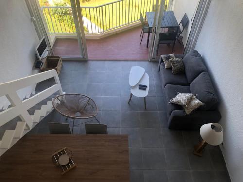 ein Wohnzimmer mit einem Sofa und einem Tisch in der Unterkunft duplex vue mer exceptionnelle in Porticcio